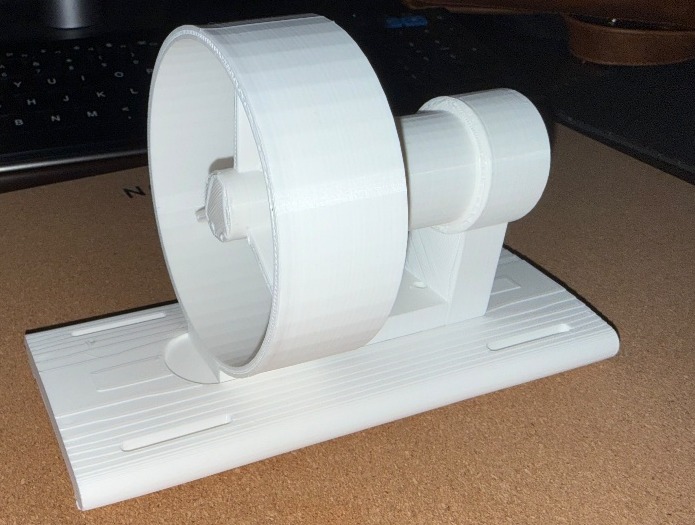 White printed cylindrical thruster stand-in fixed to a printed mounting base on a desk.